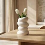 Vase spiral blanc en plastique au design spiralé captivant et minimaliste, posé sur une table avec quelques fleurs, créant une décoration moderne japandi lumineuse et élégante.