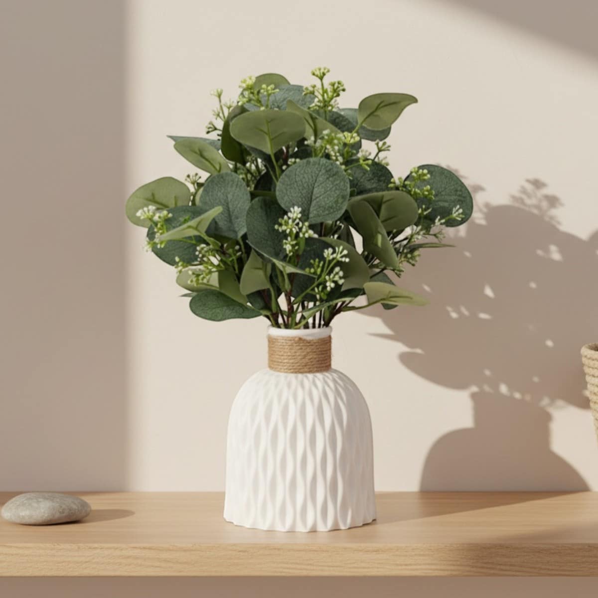Vase minimaliste blanc en plastique au style japandi avec un bouquet sur une table en bois.