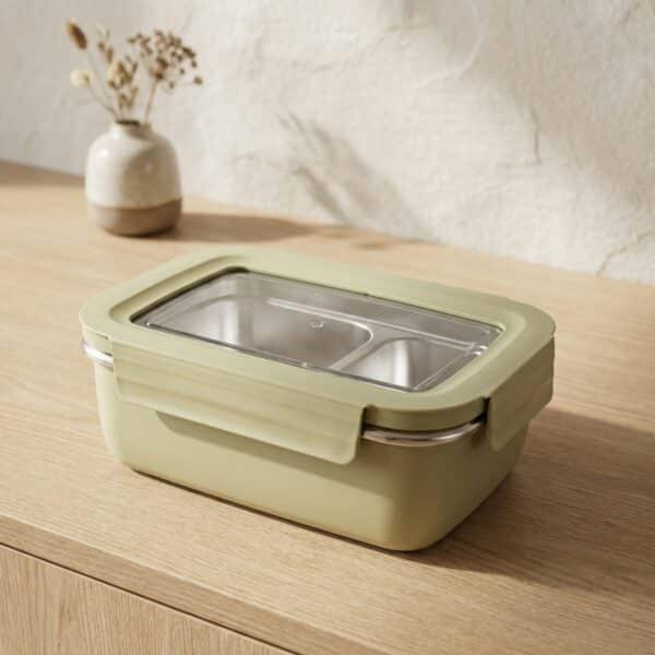 Bento japonais vert pastel en acier inoxydable, posé sur une table beige