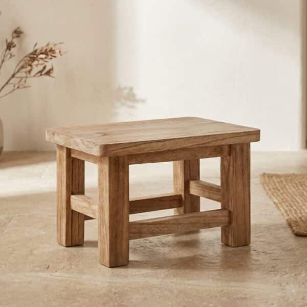 Petit tabouret Japandi rectangulaire en bois massif, sur fond beige