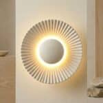 Applique murale japandi halo rayonnant blanc mat à rainures sculptées diffusant une lumière LED dorée sur mur beige.