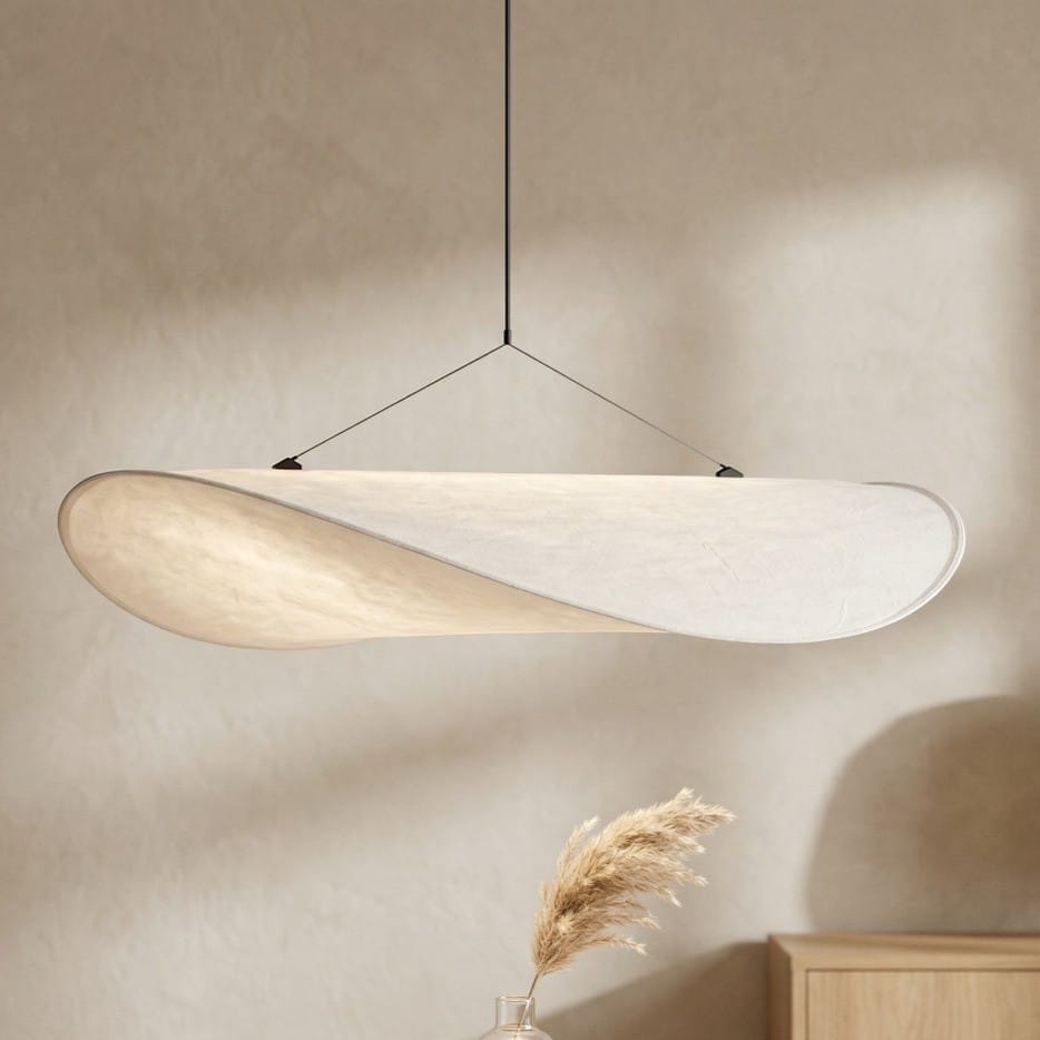 Le lustre japandi en soie blanc esprit zen et minimaliste éclaire un salon d'une lumière douce.