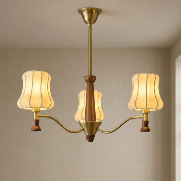 Le lustre Japandi en trois abat-jours en bois et laiton suspendu au plafond, branches en bois massif et détails dorés diffusant un lumière douce et chaleureuse.
