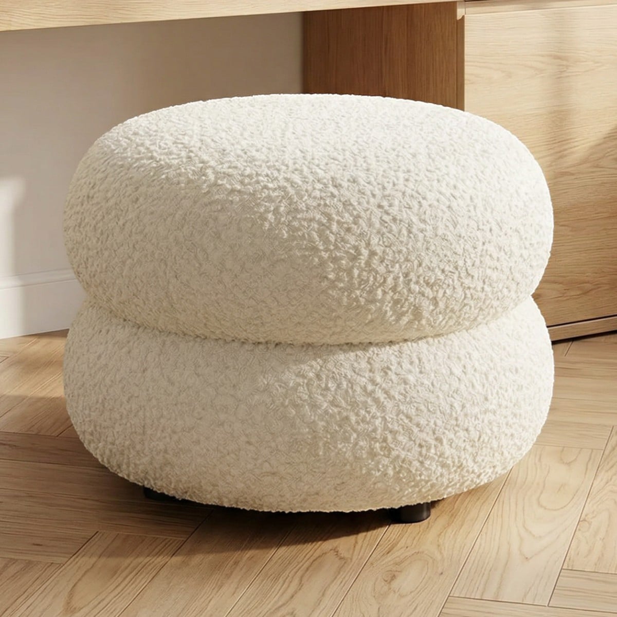 Le pouf Japandi bouclette beige style minimaliste rond en laine bouclée, formé d'anneaux superposés.