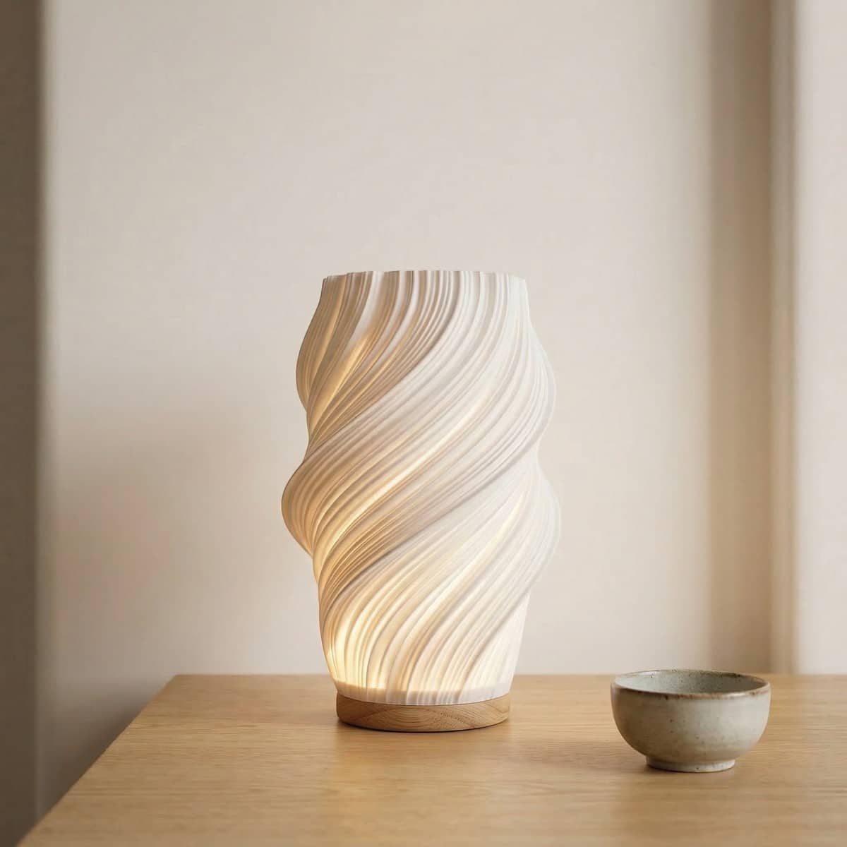 Lampe japandi torsadée lumière douce avec design ondulé lumineux, posée sur table bois, diffuse lumière chaude créant ambiance zen minimaliste élégante apaisante.