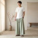 Jeune homme asiatique portant le pantalon japonais homme style samue moderne dans un salon au ton neutre.