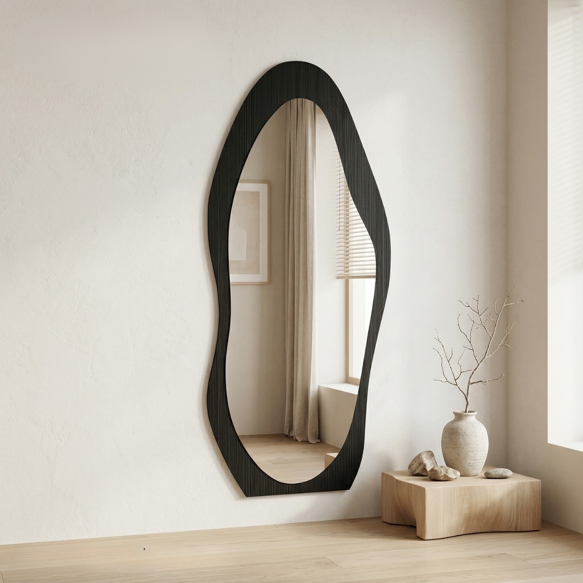Miroir japandi noir de forme organique, sur un mur beige