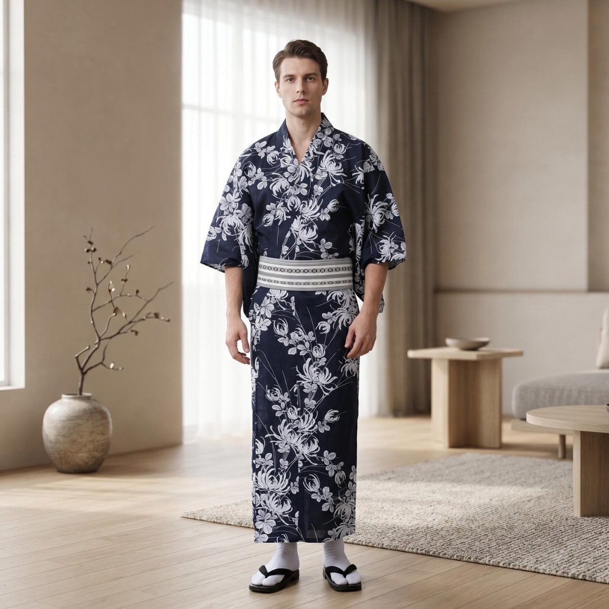 Un homme porte un kimono homme traditionnel bleu et blanc à motif fleuri, avec de grandes fleurs blanches, dans une pièce lumineuse et moderne.