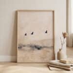 Affiche japandi avec des oiseaux minimalistes qui volent dans le ciel, posée sur un mur beige