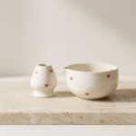 Kit pour matcha avec un bol japonais en céramique blanche avec des coeurs, sur une table beige
