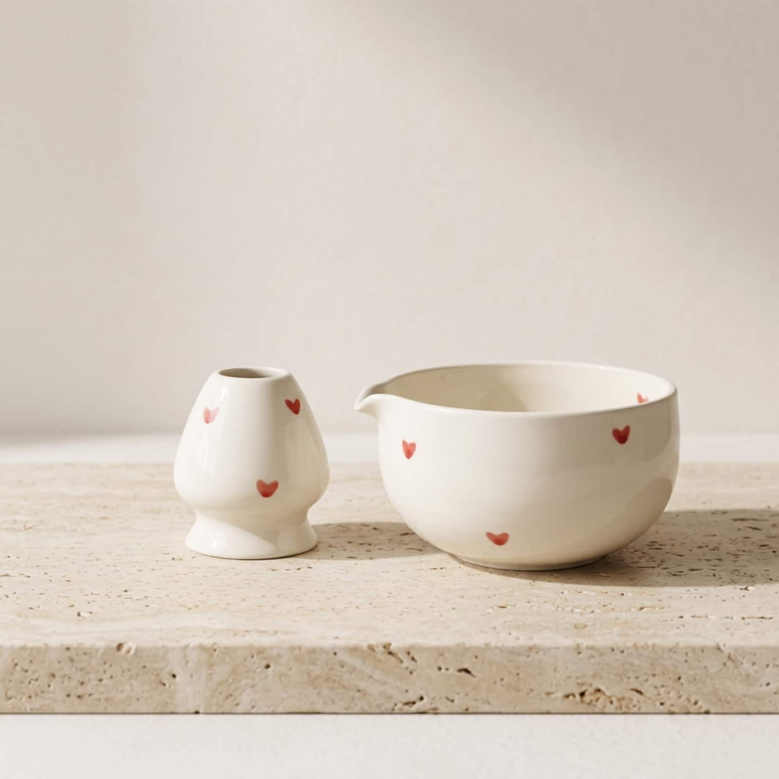 Kit pour matcha avec un bol japonais en céramique blanche avec des coeurs, sur une table beige